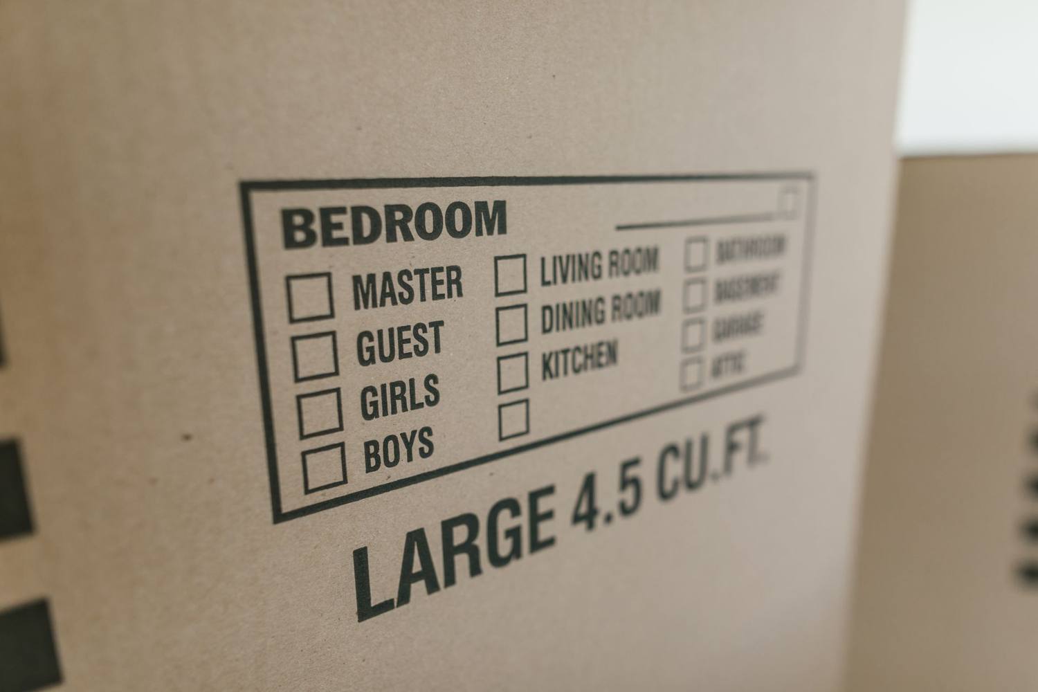 Étiquette sur une boîte en carton indiquant les types de pièces pour le déménagement, grande taille de 4,5 pi³.